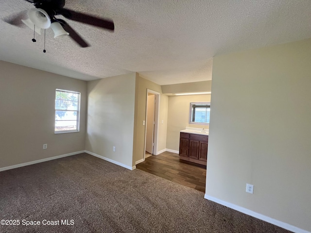 carpeted spare room with ceiling fan and a textured ceiling