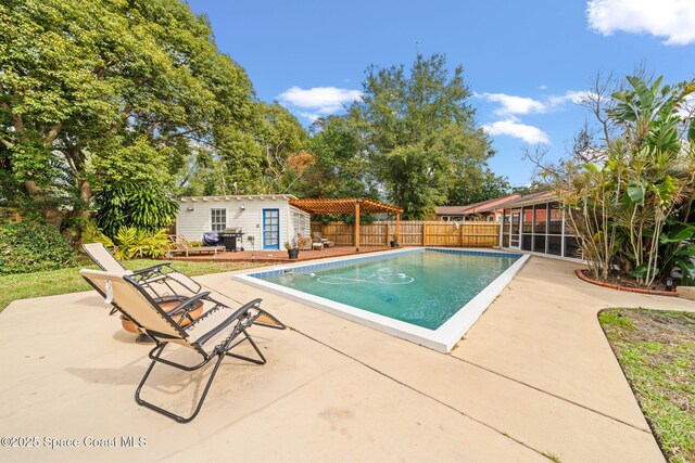 view of pool featuring area for grilling, a pergola, an outdoor structure, and a patio area