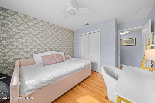 bedroom featuring light hardwood / wood-style flooring, a closet, and ceiling fan