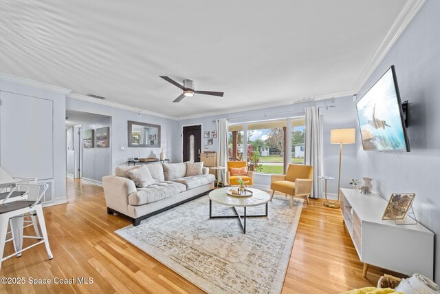 living room featuring crown molding, ceiling fan, and light hardwood / wood-style floors