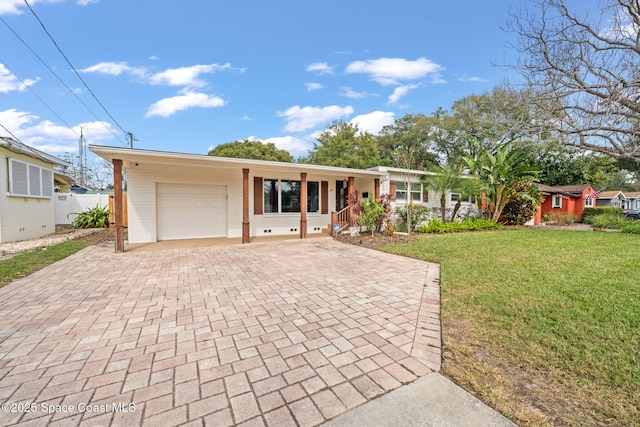 ranch-style house featuring a carport, a garage, covered porch, and a front lawn