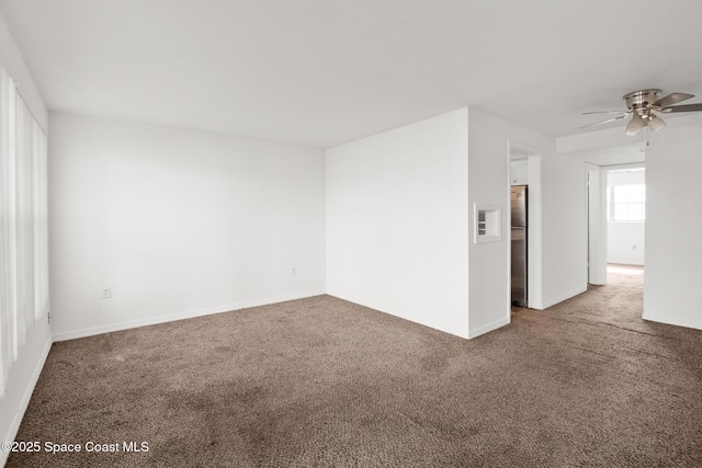 spare room featuring carpet, baseboards, and a ceiling fan