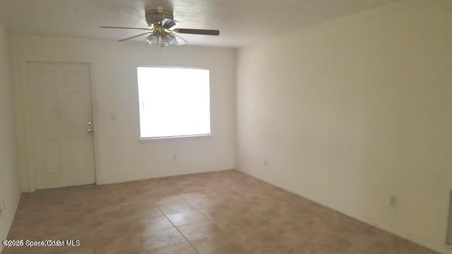 tiled empty room featuring ceiling fan