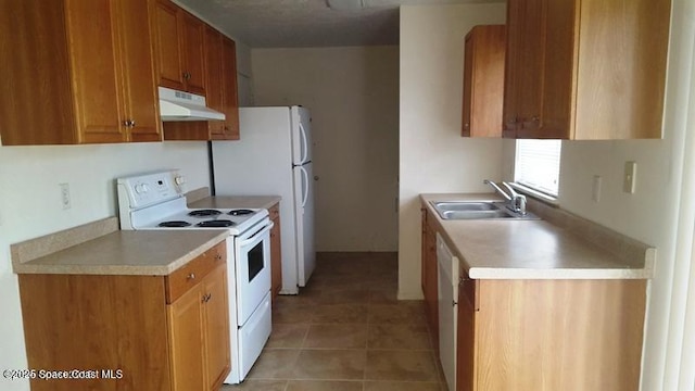 kitchen featuring white appliances, sink, and light tile patterned floors