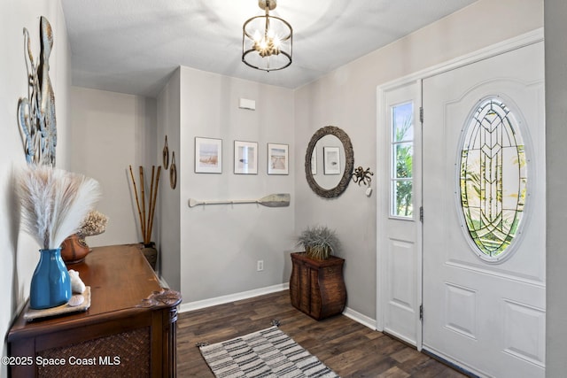 entrance foyer featuring dark hardwood / wood-style flooring and a notable chandelier