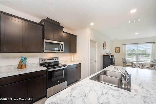 kitchen with stainless steel appliances, sink, and dark brown cabinetry