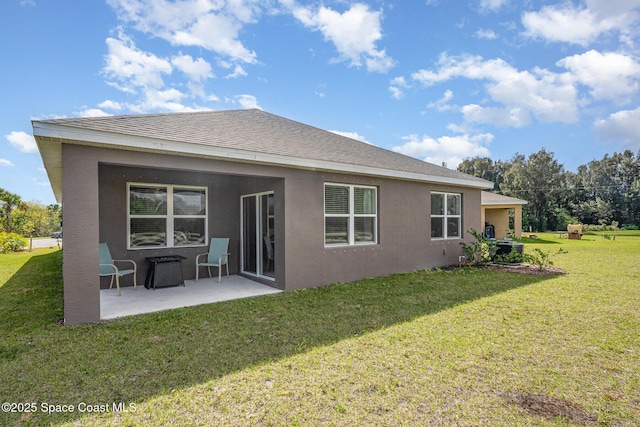 rear view of house with a lawn and a patio