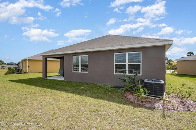 rear view of property featuring central AC unit, a patio, and a lawn