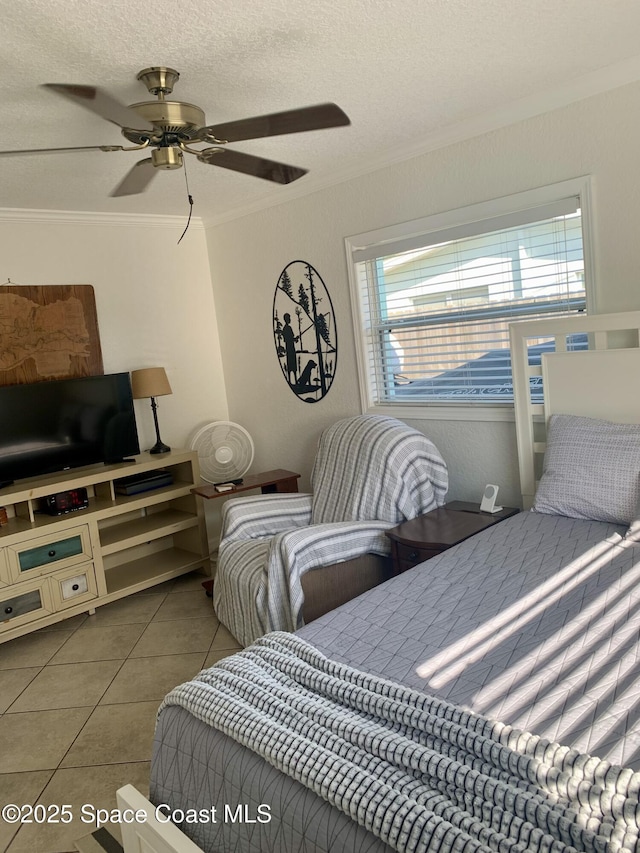 tiled bedroom featuring ceiling fan, ornamental molding, and a textured ceiling