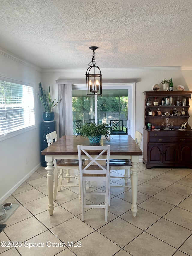 dining room with ornamental molding, a chandelier, a textured ceiling, and light tile patterned floors