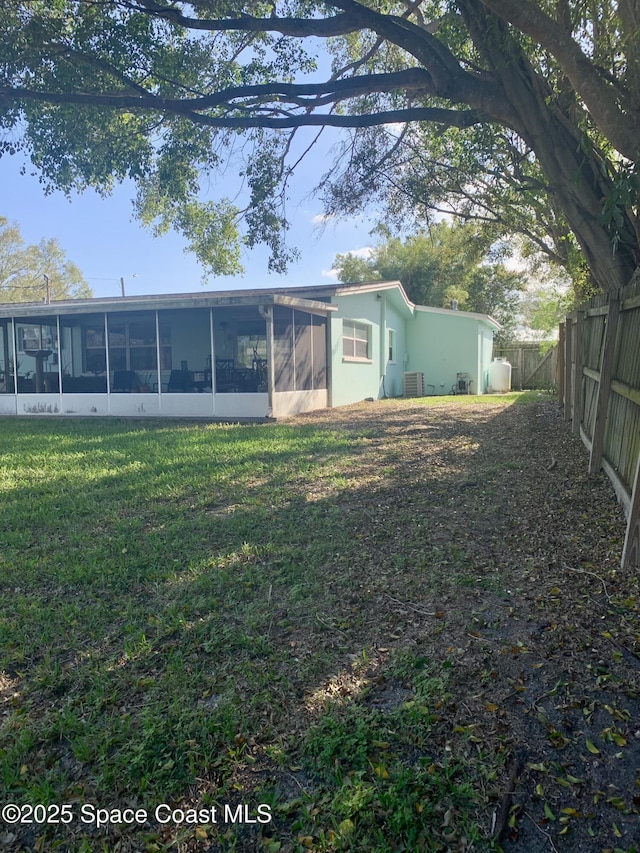 back of property featuring a sunroom and a lawn