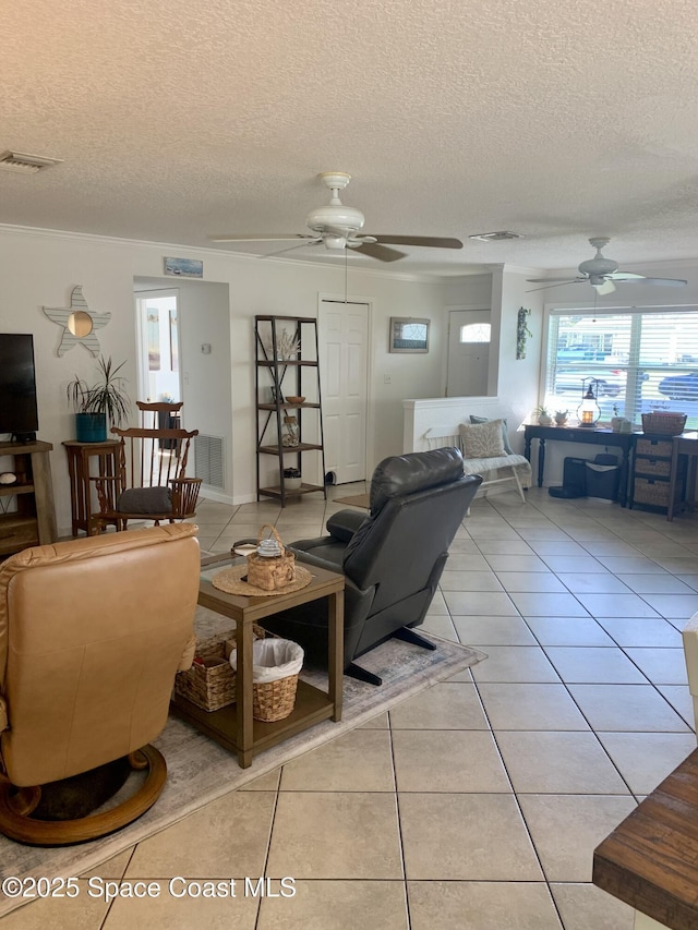 tiled living room featuring ceiling fan and a textured ceiling