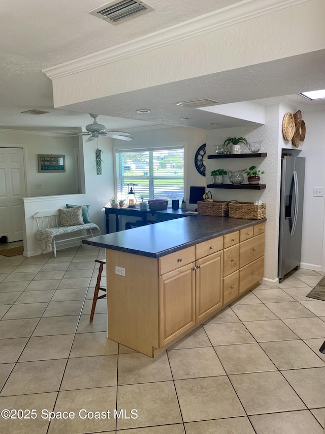 kitchen featuring light tile patterned floors, crown molding, ceiling fan, and stainless steel refrigerator with ice dispenser