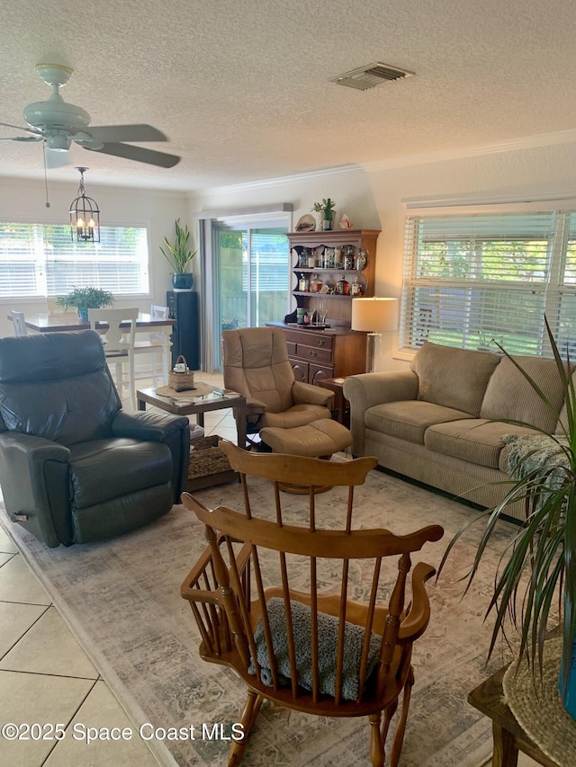 tiled living room with ceiling fan and a textured ceiling