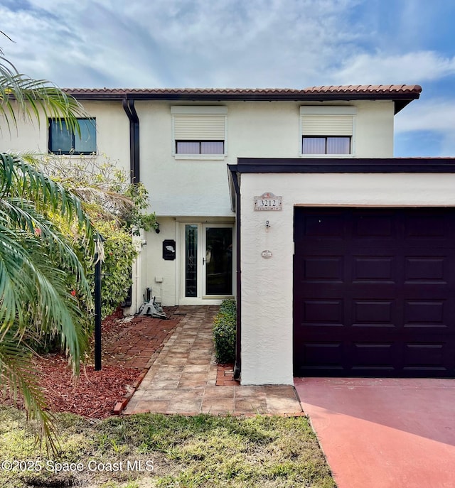 mediterranean / spanish house featuring french doors and a garage