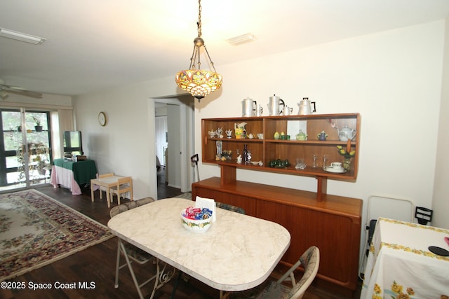 dining area featuring dark hardwood / wood-style floors and ceiling fan with notable chandelier