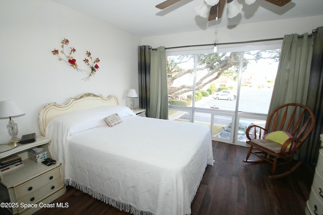 bedroom featuring multiple windows, dark hardwood / wood-style flooring, ceiling fan, and access to outside