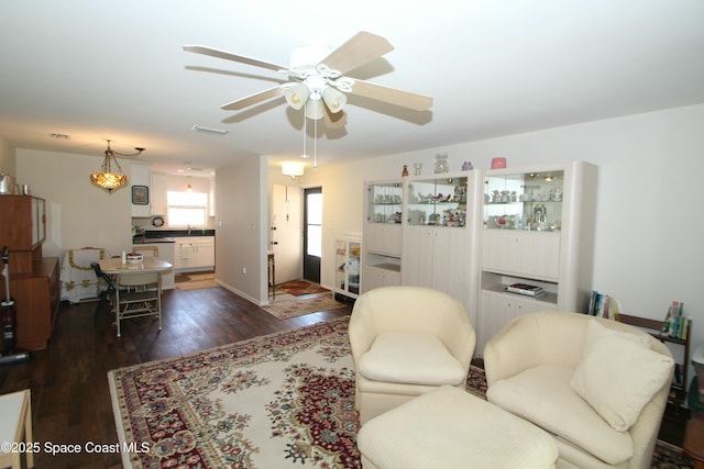 living room featuring sink, dark wood-type flooring, and ceiling fan