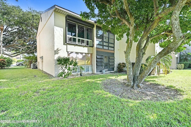 view of front facade with central AC unit and a front yard