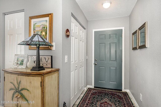 doorway to outside with a textured ceiling