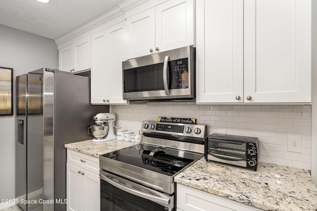 kitchen with white cabinetry, a textured ceiling, appliances with stainless steel finishes, light stone countertops, and decorative backsplash