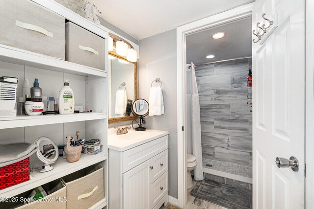 bathroom with vanity, curtained shower, and toilet