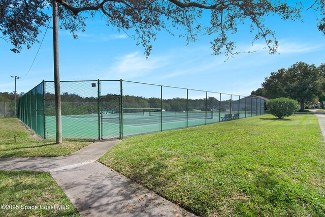 view of tennis court featuring a yard