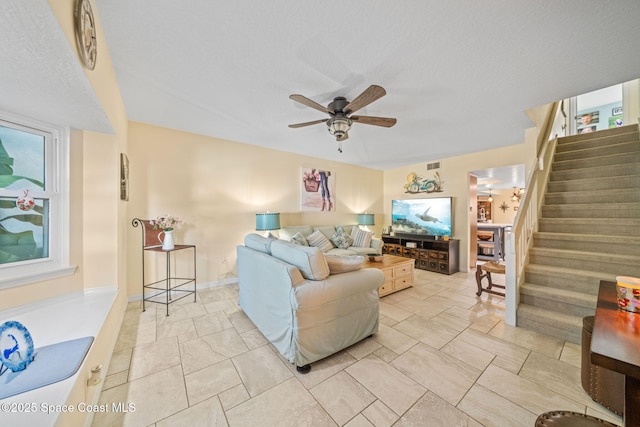 living room with a textured ceiling and ceiling fan