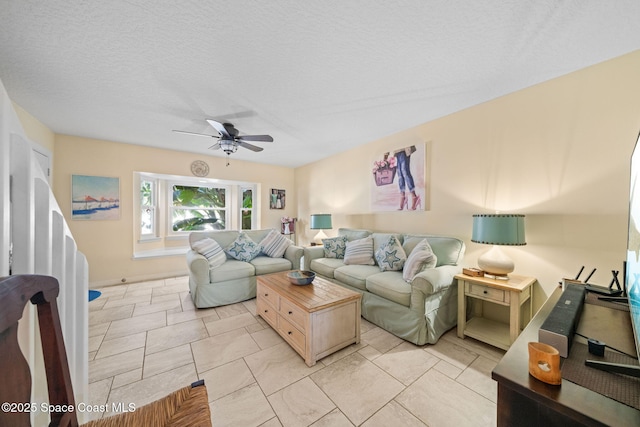 living room featuring ceiling fan and a textured ceiling