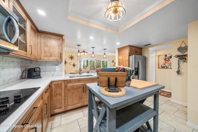 kitchen featuring pendant lighting, a raised ceiling, tasteful backsplash, sink, and stainless steel appliances