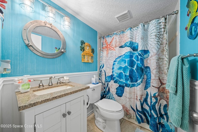 bathroom with tile patterned floors, toilet, a shower with curtain, a textured ceiling, and vanity