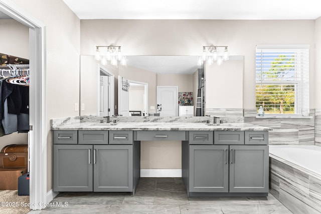 bathroom with vanity and a relaxing tiled tub