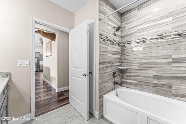 bathroom with vanity and tiled shower / bath combo