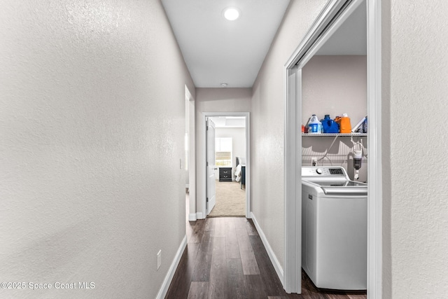 corridor with dark hardwood / wood-style flooring and washer and dryer