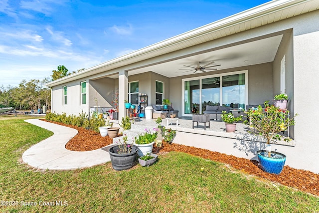 rear view of property with a yard and ceiling fan