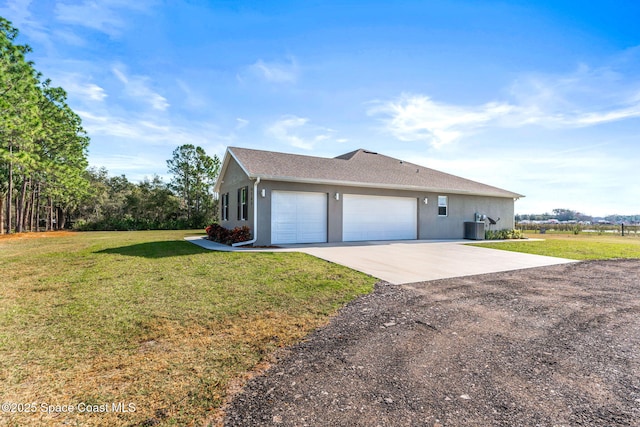 view of front of home with a garage, central AC unit, and a front lawn