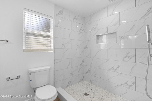 bathroom with tiled shower and toilet