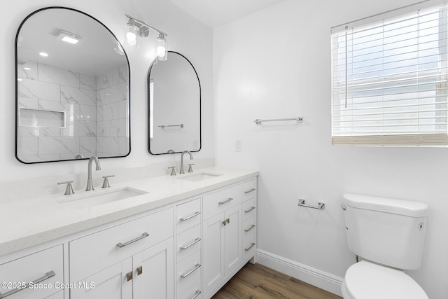 bathroom featuring vanity, wood-type flooring, toilet, and a tile shower