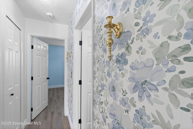 hallway with wood-type flooring and a textured ceiling