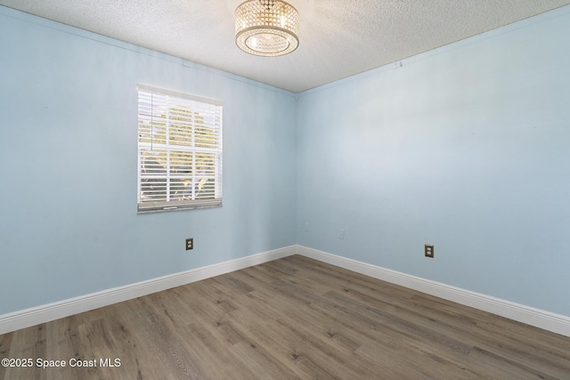 unfurnished room with wood-type flooring and a textured ceiling