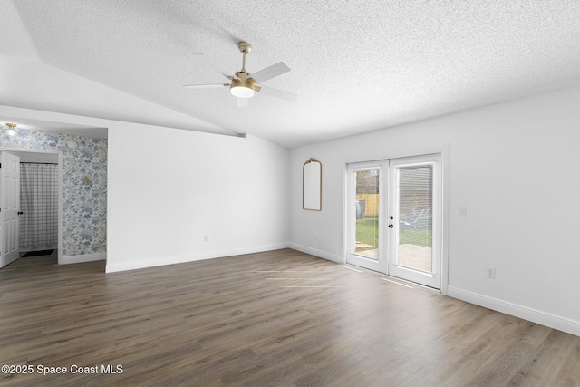 unfurnished room featuring french doors, dark hardwood / wood-style floors, vaulted ceiling, and a textured ceiling