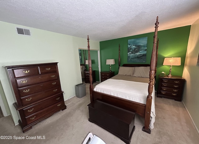 bedroom featuring light carpet and a textured ceiling