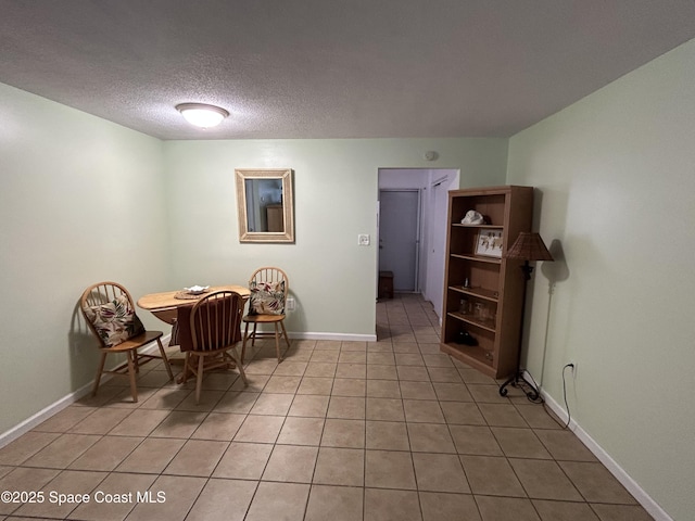 dining space featuring light tile patterned floors and a textured ceiling