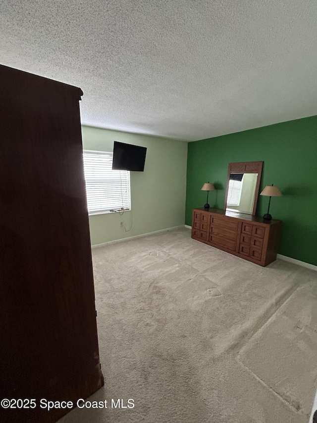 carpeted bedroom featuring multiple windows and a textured ceiling