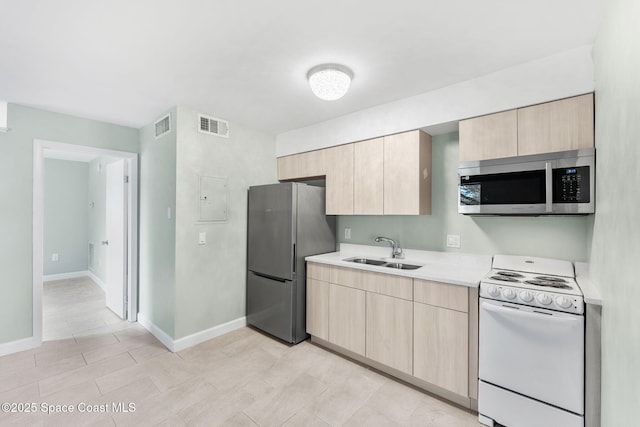 kitchen with stainless steel appliances, sink, and light brown cabinets