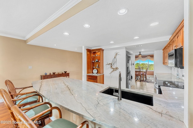 kitchen with range with electric stovetop, sink, a kitchen bar, ornamental molding, and kitchen peninsula