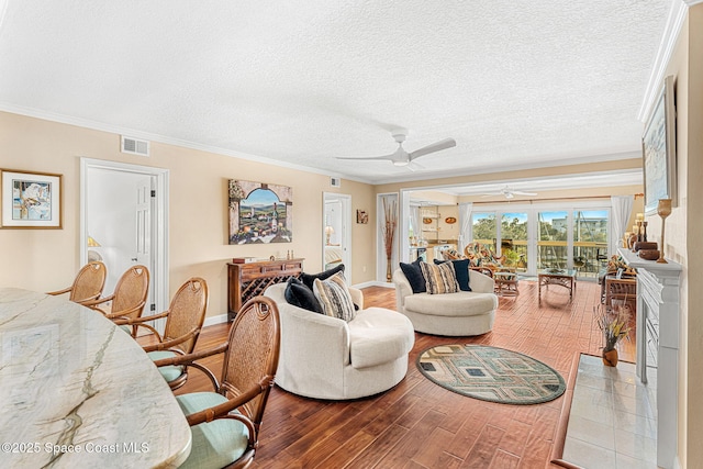 living room with crown molding, ceiling fan, a textured ceiling, and light hardwood / wood-style floors