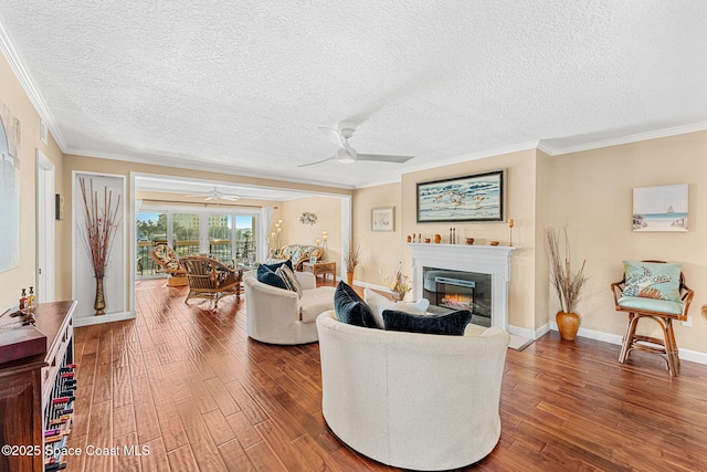 living room with hardwood / wood-style floors, a textured ceiling, ornamental molding, and ceiling fan