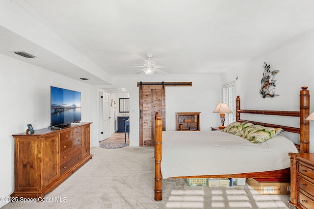 bedroom featuring light carpet, ornamental molding, a barn door, and ceiling fan