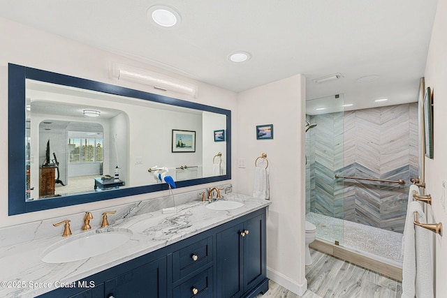 bathroom with vanity, tiled shower, hardwood / wood-style floors, and toilet